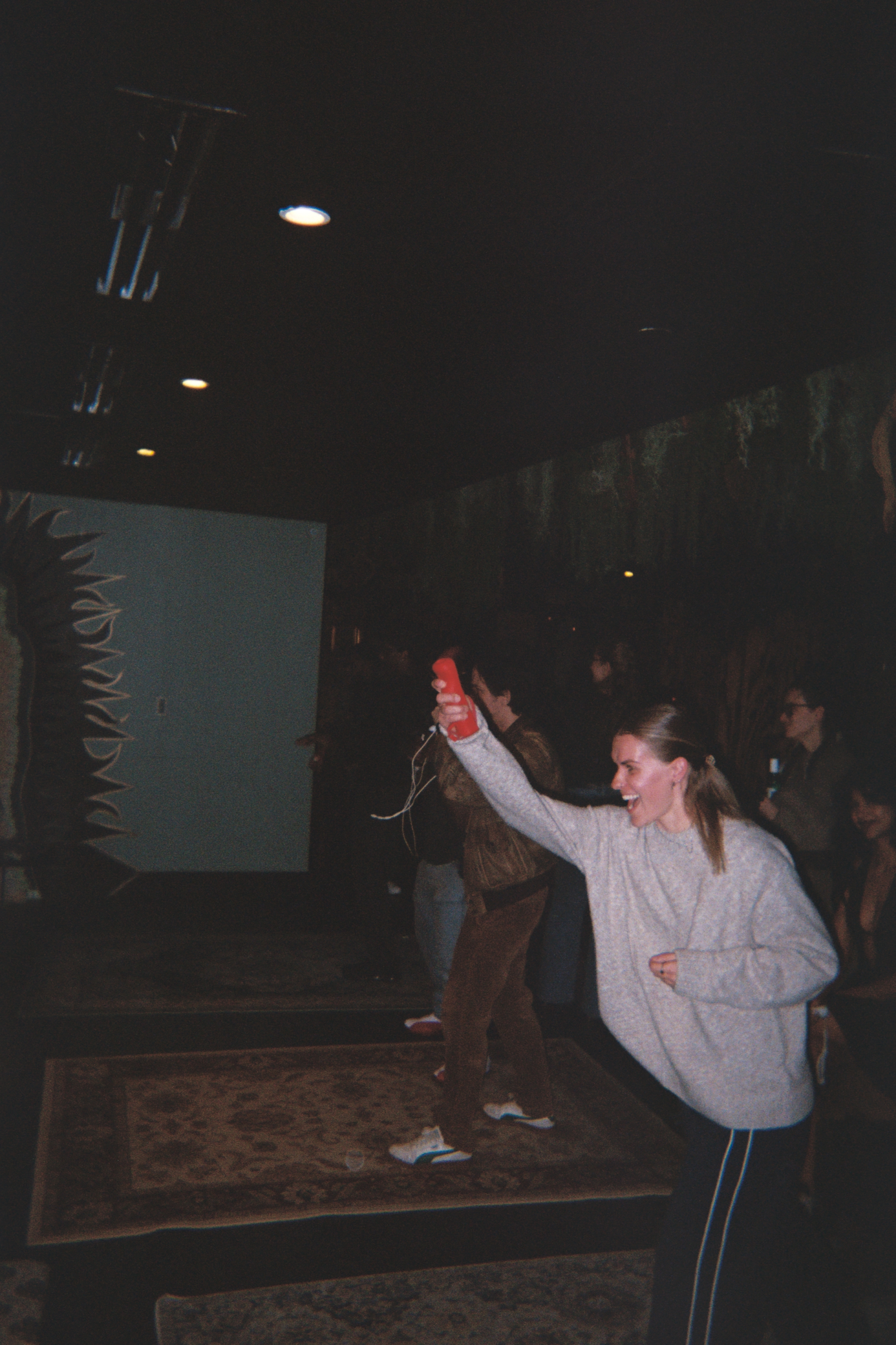 A guest laughing while playing Wii with a red controller